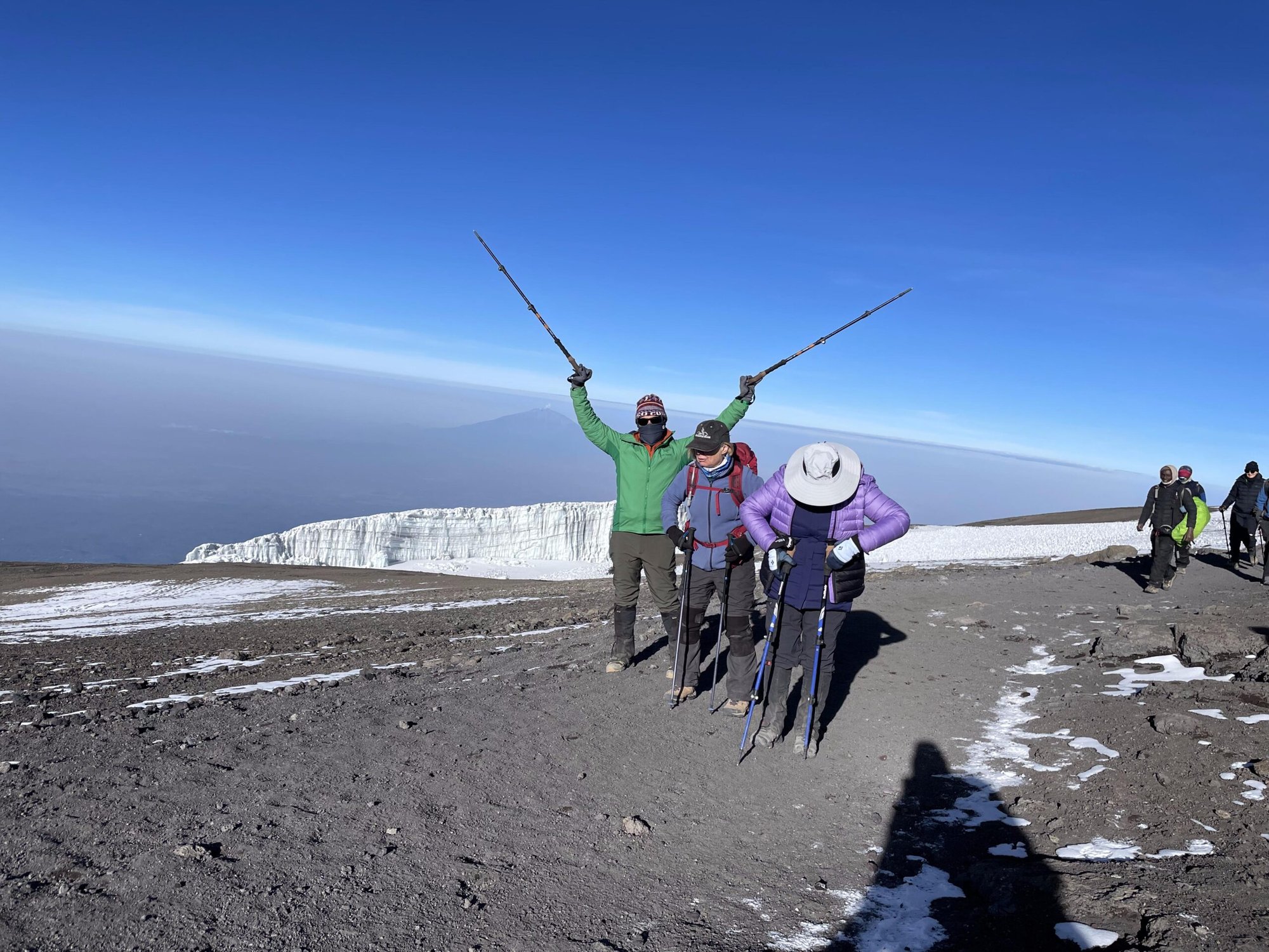 Trekkers celebrating beside the summit glaciers on Kilimanjaro
