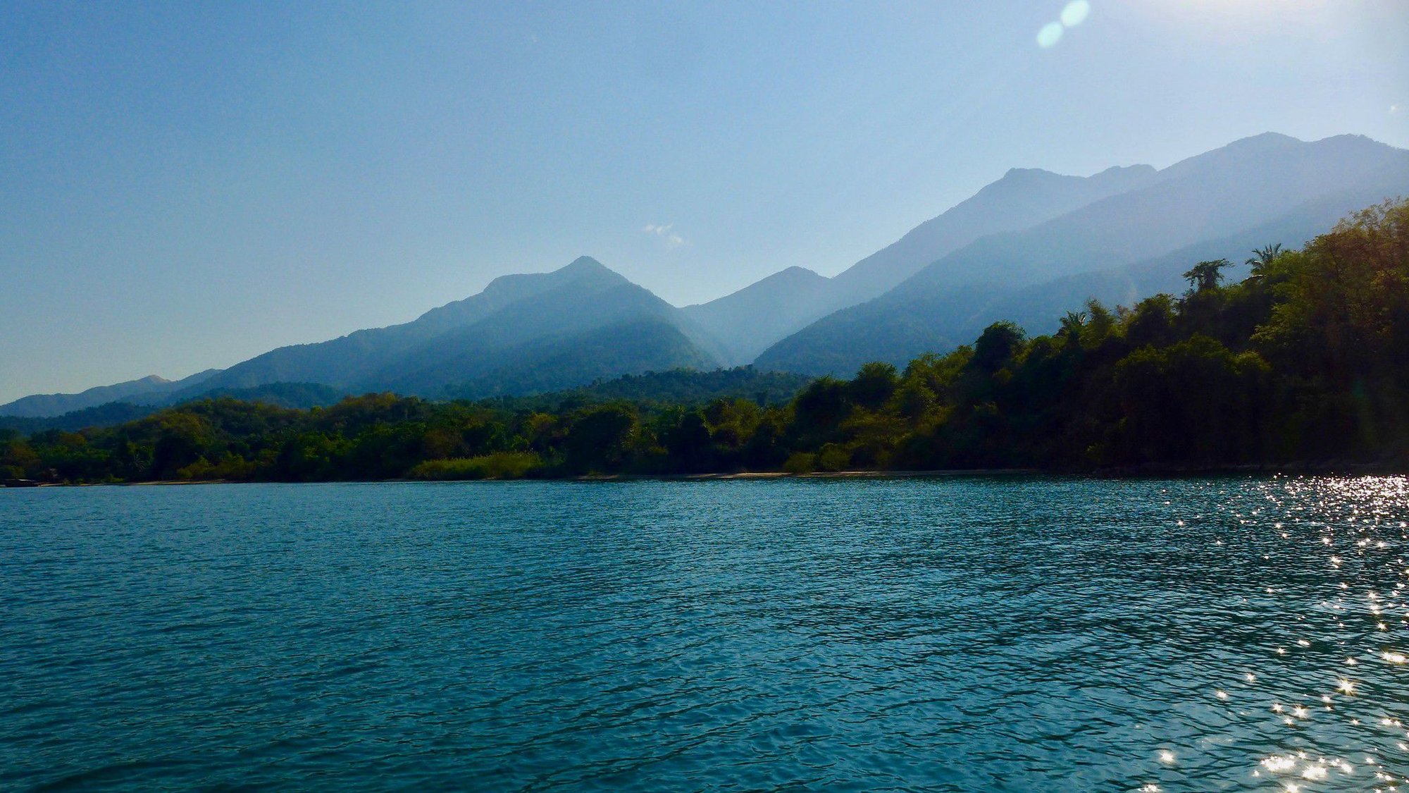 The Mahale mountains rising behind the forested shore of Lake Tanganyika